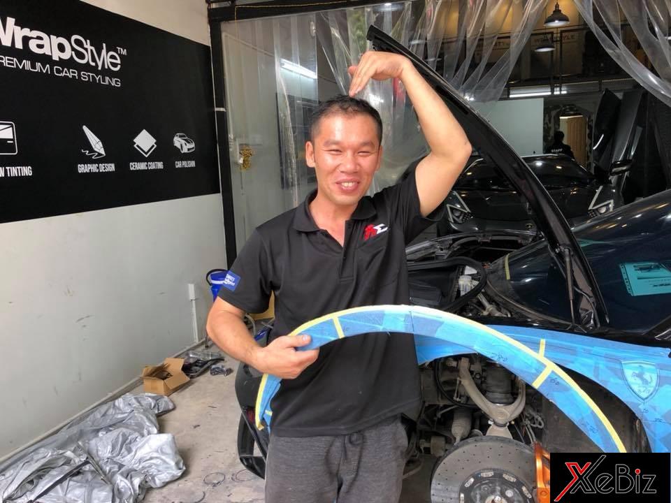 Một người thợ Nhật tạo dáng vui vẻ bên siêu xe Ferrari 488 GTB đang chuẩn bị độ Liberty Walk tại Việt Nam