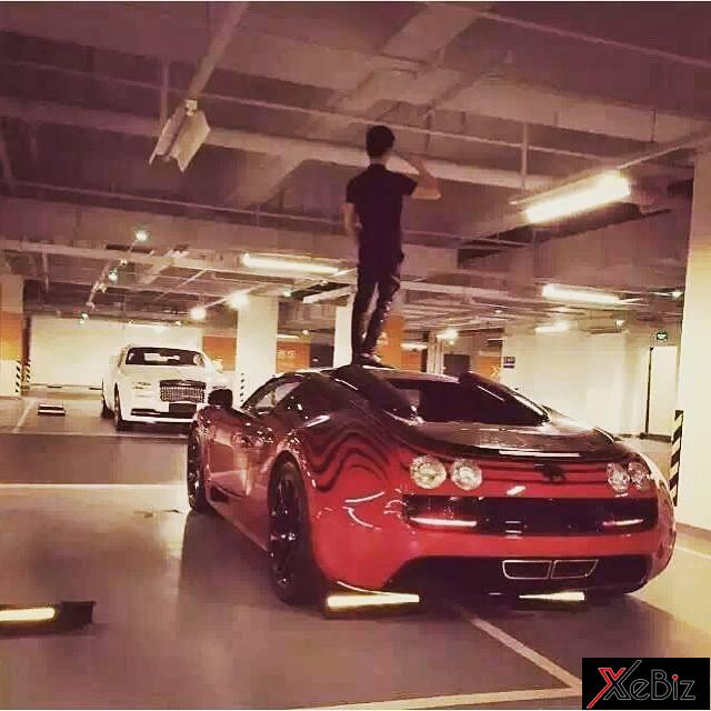 Nam thanh niên mang giày và đứng trên nóc siêu xe Bugatti Veyron Grand Sport Vitesse L’Or Rouge