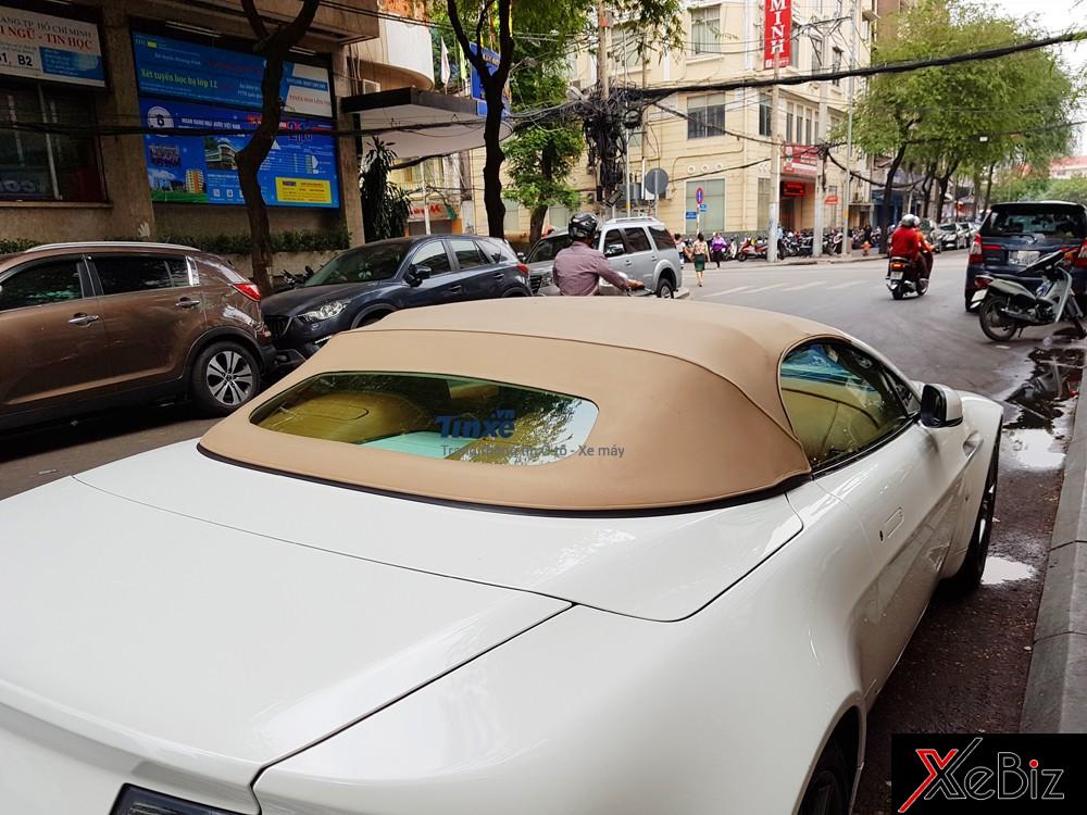 Đối lập với bộ áo trắng, chiếc xe sang mui trần Aston Martin V8 Vantage Roadster có phần mui vải màu be bắt mắt.